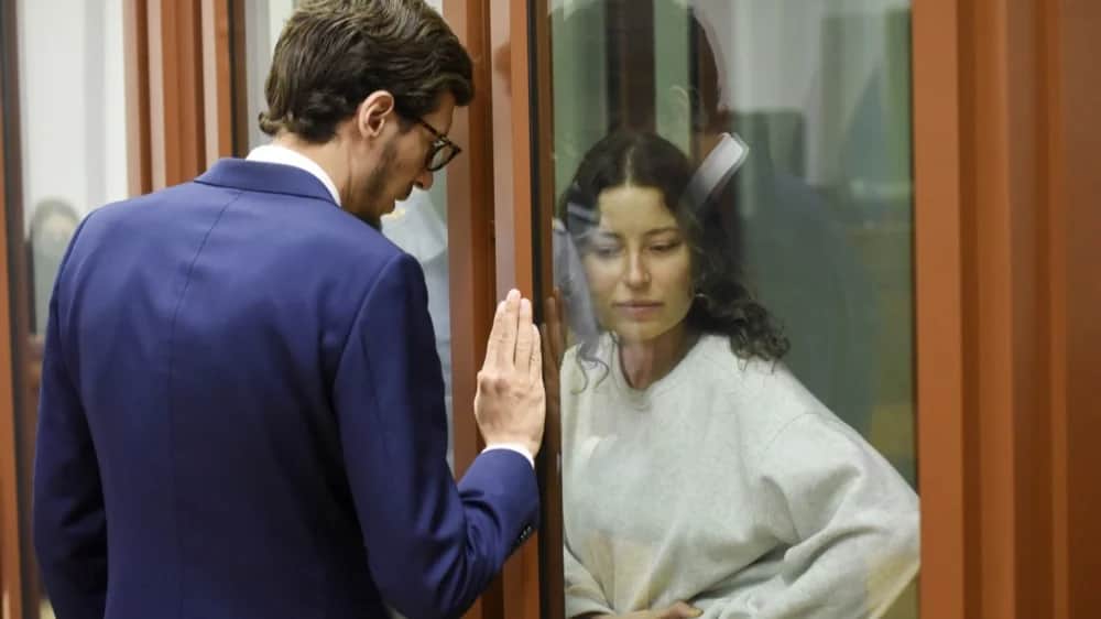 Ksenia Karelina speaks with her lawyer during her August court hearing. Photo: EPA-EFE/STRINGER