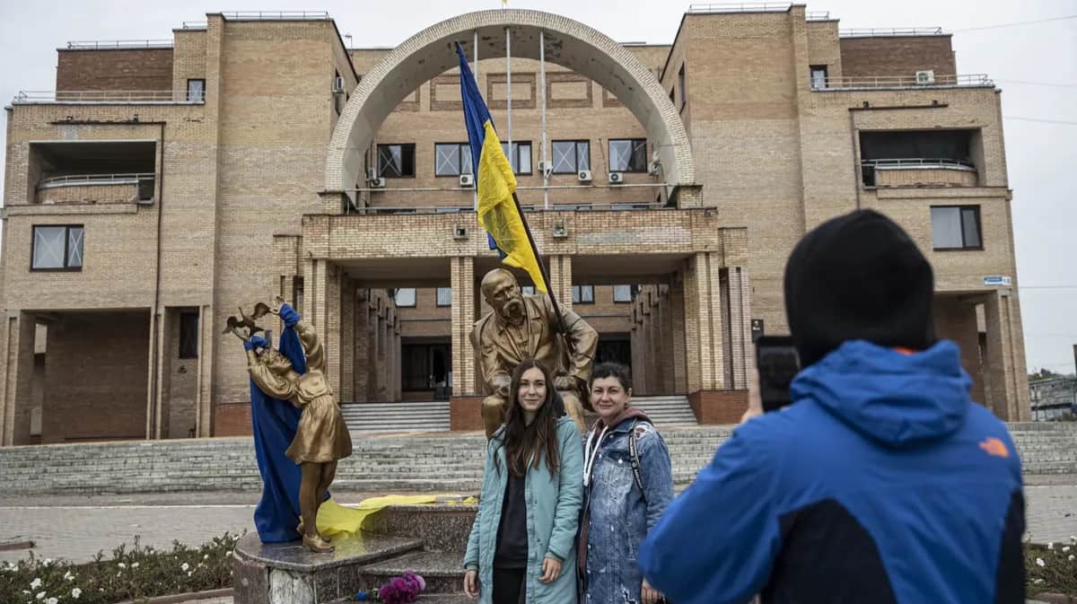 Люди позируют перед статуей Тараса Шевченко после освобождения города Балаклея Харьковской области армией Украины, 11 сентября 2022 года. Фото: Metin Aktas / Anadolu Agency / Getty Images