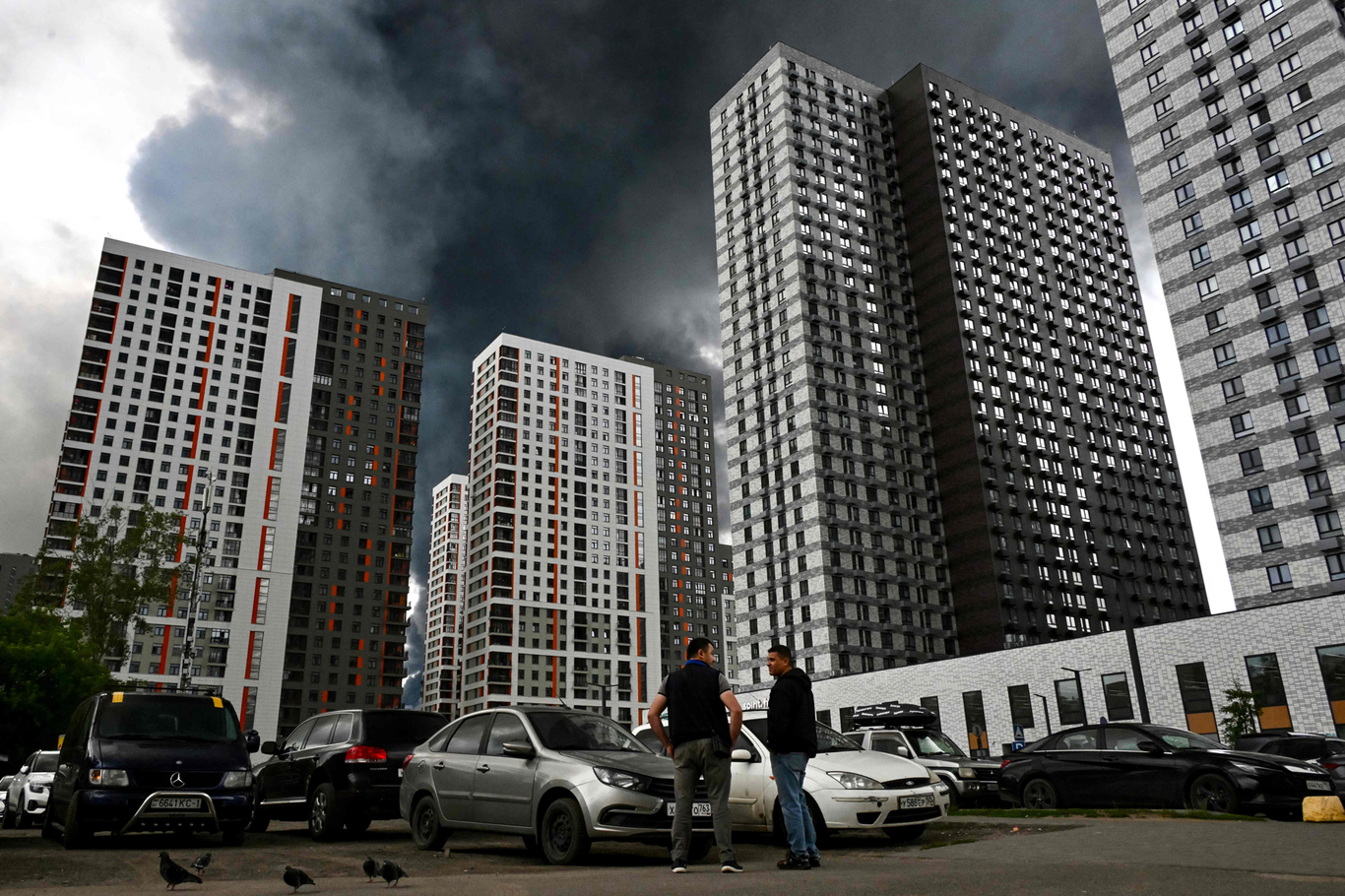 Прохожие на улице жилого района, окутанного черным дымом. Москва. 18 июня 2026 года. Фото: AFP / Scanpix / LETA
