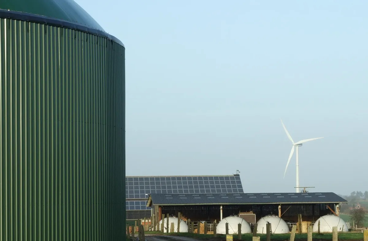 An installation for biogas production, photovoltaic panels, and a wind turbine, Schleswig-Holstein, Germany. Photo: <a href="https://commons.wikimedia.org/w/index.php?curid=7369966" rel="noopener noreferrer" title="https://commons.wikimedia.org/w/index.php?curid=7369966">Wikimedia Commons</a>, Florian Gerlach (Nawaro). CC BY-SA 3