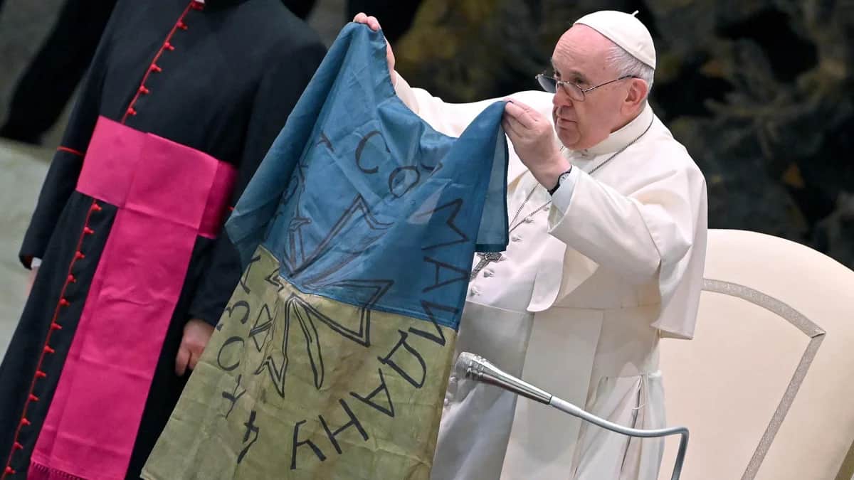 Папа Франциск показывает в Ватикане флаг Украины, присланный ему из Бучи, 6 апреля 2022 года. Фото: Ettore Ferrari / EPA-EFE