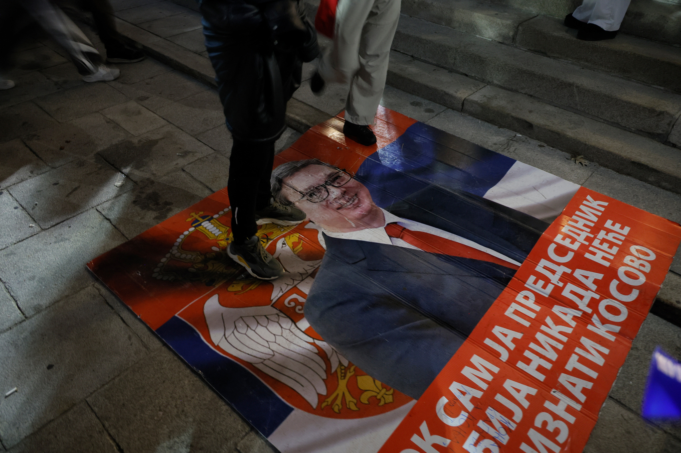 Сторонники «Студенческого списка» стоят на плакате с изображением Александара Вучича. Белград, Сербия. 25 октября 2026 года. Фото: Marko Djokovic / EPA