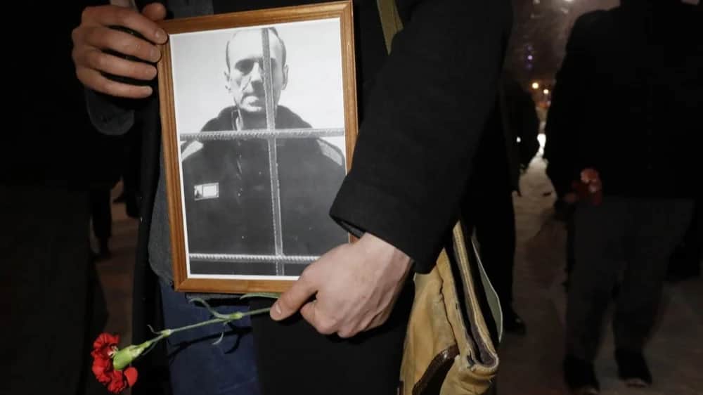 People lay flowers and light candles next to the photo of Russian late opposition leader Alexey Navalny during a vigil following his death, near the memorial to political prisoners in St. Petersburg, Russia, 16 February 2024. Photo: EPA/ANATOLY MALTSEV