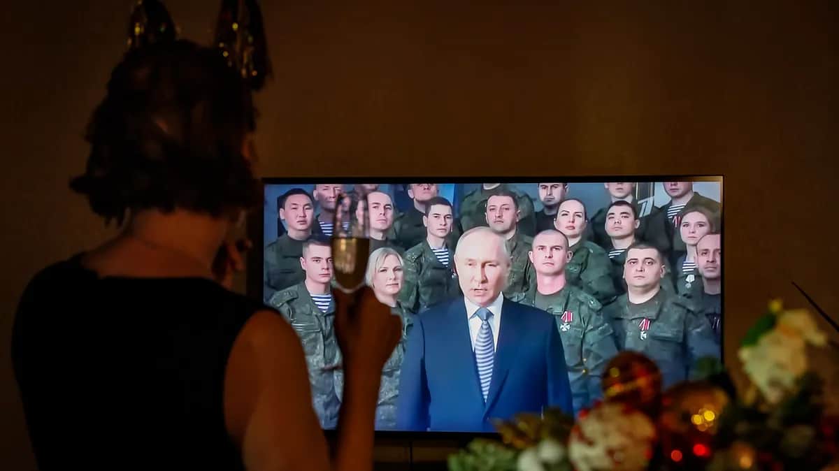 A woman listens to Vladimir Putin’s annual New Year’s address to the nation. Moscow, Russia, 31 December 2022. EPA-EFE/YURI KOCHETKOV