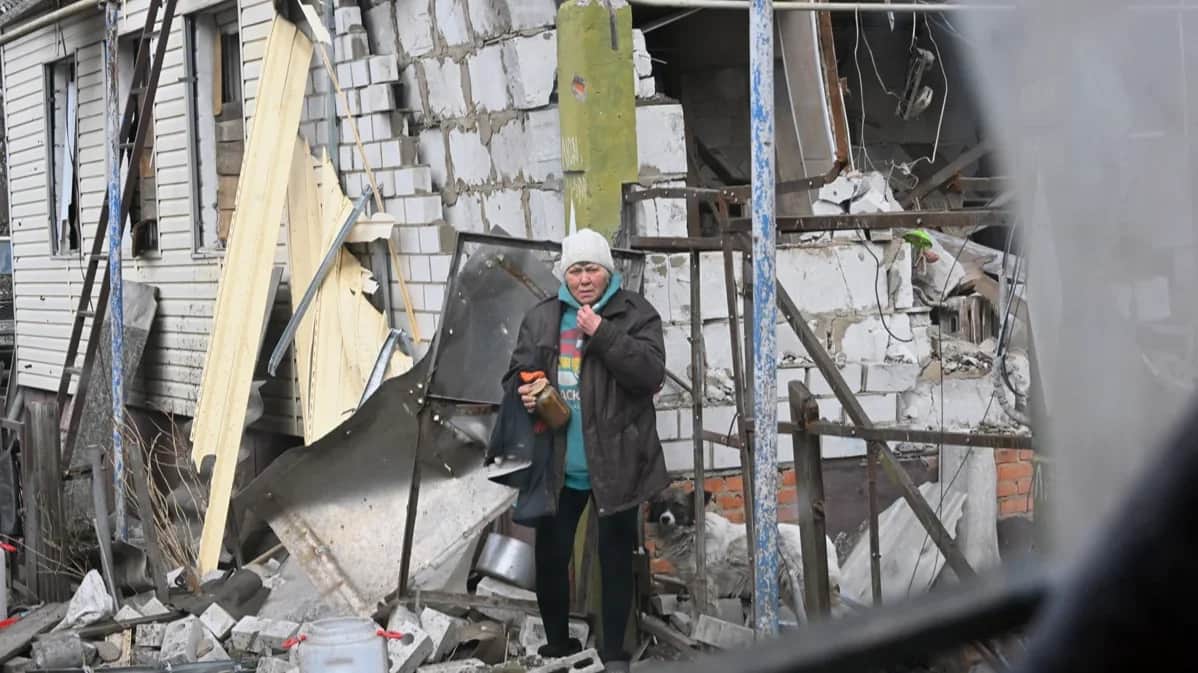 A woman stands outside a house in Sudzha destroyed by shelling, 19 March 2025. Photo: Anatoly Zhdanov / Kommersant / Sipa USA / Vida Press