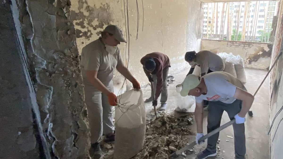 Жители дома расчищают последствия обстрела. Ирпень, Гостомельское шоссе, 24/1. Фото: Виктория Журавлева