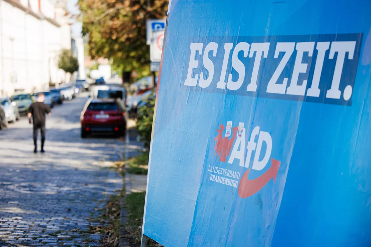 Агитационный плакат партии «Альтернатива для Германии» (AfD) с наклейками «Расизму нет альтернативы» и «Ваш голос против AfD» в день региональных выборов в Потсдаме, Бранденбург, Германия, 22 сентября 2024 года. Фото: Clemens Bilan / EPA-EFE