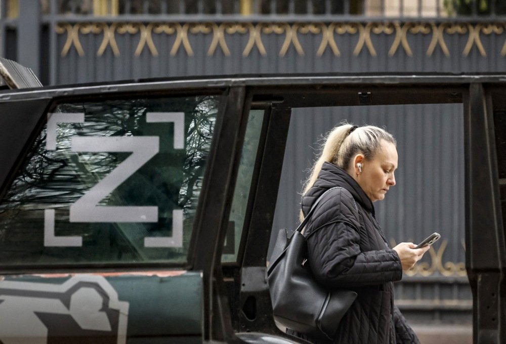 A woman walks past a car with a pro-war symbol in Moscow, Russia, 28 October 2024. Photo: EPA/YURI KOCHETKOV