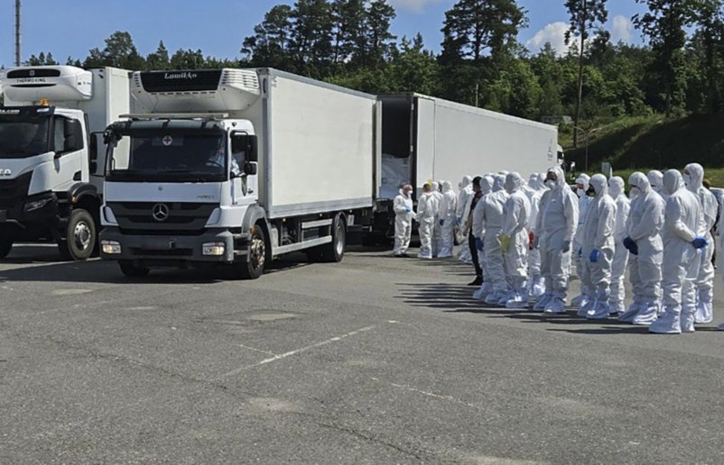 Ukrainian officials in hazmat suits receive the remains of fallen Ukrainian soldiers at an undisclosed location, Ukraine, 16 June 2025. Photo: Coordination Headquarters for the Treatment of Prisoners of War