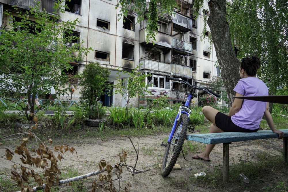 A local woman sits in front of the damaged residential building in Shebekino, Belgorod region, Russia on 2 July 2023. Photo: EPA-EFE/STRINGER
