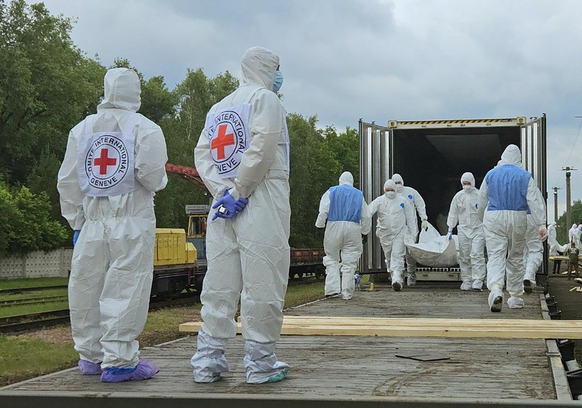 Ukrainian officials in hazmat suits receive the remains of fallen Ukrainian soldiers at an undisclosed location, Ukraine, 13 June 2025. Photo: Coordination Headquarters for the Treatment of Prisoners of War