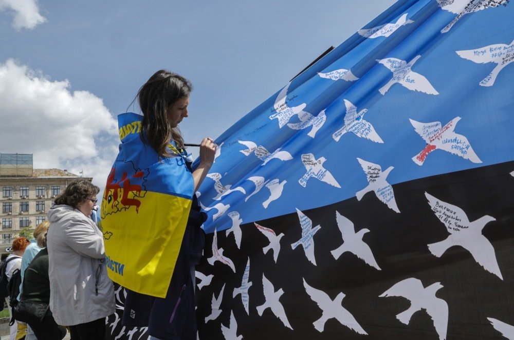 Ukrainians write the names of missing people on a placard during a rally in support of prisoners of war, at Independence Square in Kyiv, Ukraine, 30 April 2025. Photo: EPA-EFE/SERGEY DOLZHENKO